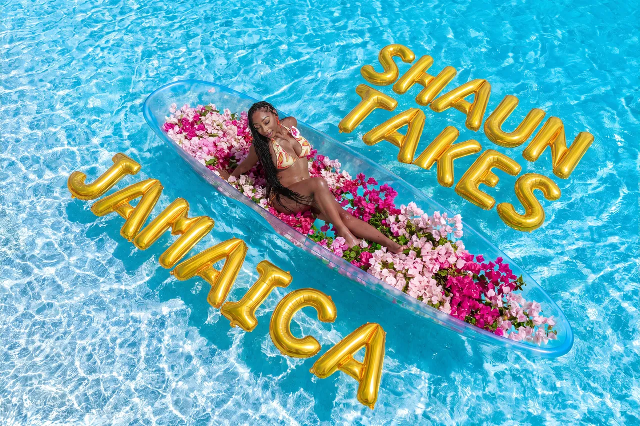 Aerial portrait of a guest in a pink-flower clear kayak with custom gold celebration balloons