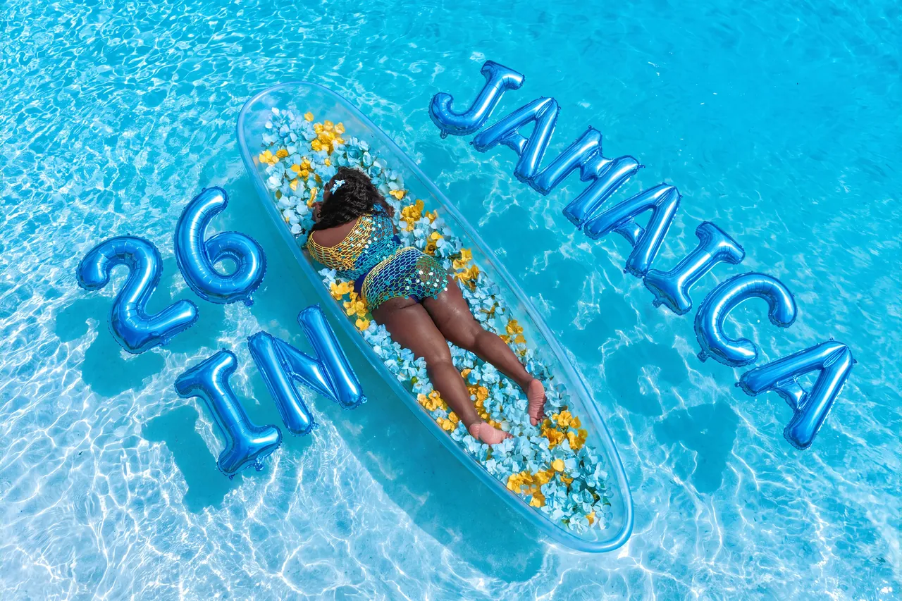 Guest in a flower-filled clear kayak with blue Jamaica birthday balloons