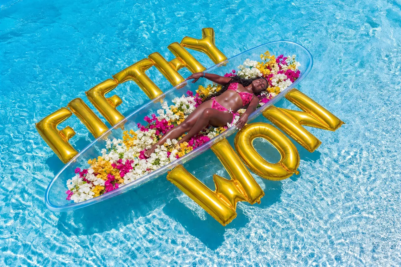 Aerial flower-kayak portrait with a large custom gold-letter arrangement